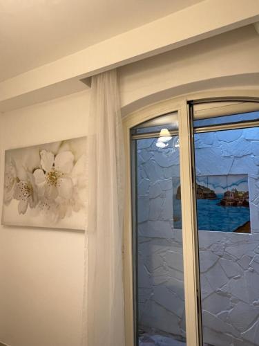 伊斯基亚Maison Mele Ischia的滑动玻璃门,带窗户和绘画