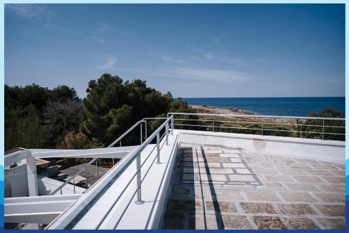 圣伊西多罗Casa Vacanza La Torre的通往海滩的楼梯,背景是大海
