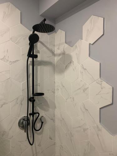 特拉维夫Ajami Guest House的浴室铺有白色瓷砖,设有淋浴。