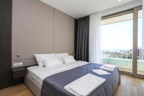 布德瓦Apartments Lux sea view的一间卧室设有一张大床和大窗户