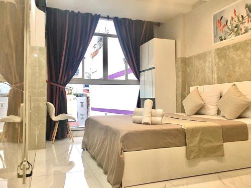 胡志明市Saigon Cozy Hotel的一间卧室设有一张大床和一个窗户。