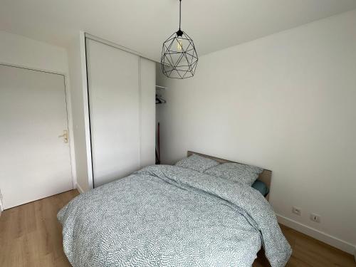 凯恩Appartement Caen的一间卧室配有一张床和吊灯