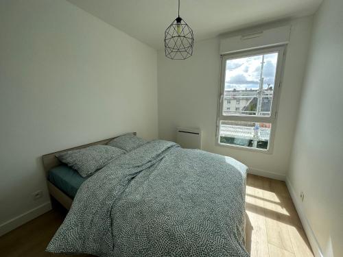 凯恩Appartement Caen的一间卧室设有一张床和一个窗口