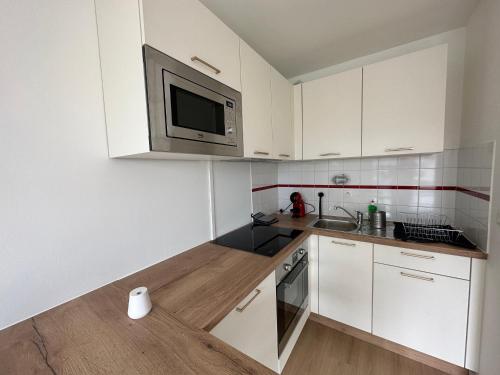 凯恩Appartement Caen的厨房配有白色橱柜和微波炉