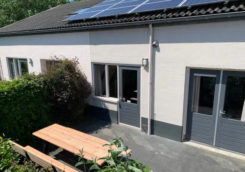 彼得比伦瓦登胡斯小型家庭旅馆的屋顶上设有太阳能电池板和长凳的房子