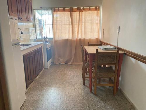 卡梅隆Departamento vivienda completo的厨房配有桌椅和水槽。