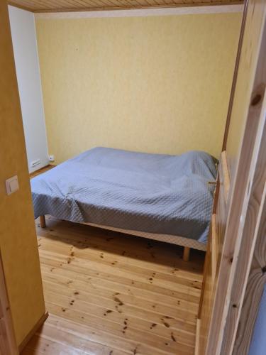 萨翁林纳Golfhelmi的铺有木地板的客房内的一张小床