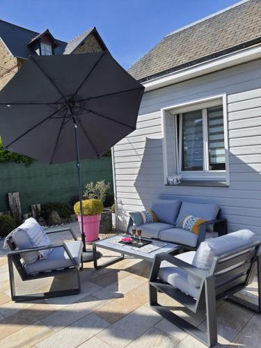 圣马洛Véritable maison de vacances à 500 m des plages的庭院配有两把椅子和一把遮阳伞