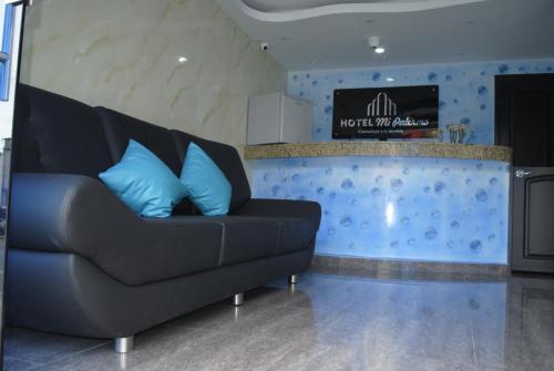 布卡拉曼加Hotel Mi Palermo的客房内的黑色沙发,配有蓝色枕头
