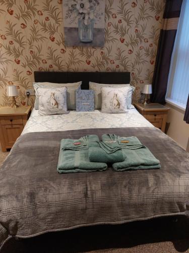 布莱克浦PONDEROSA的一间卧室配有一张床,上面有两条毛巾
