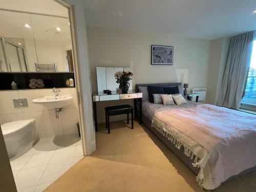 伦敦Modern 2 Bedroom 2 Bath Apartment with River View的一间卧室配有一张床和一个水槽和一个浴缸