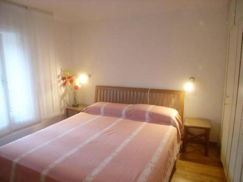 格拉多Calle Burchio的一间卧室配有一张带粉色毯子的大床