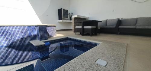 蓬塔雷纳斯Casa de playa con piscina y jacuzzi privado的客厅,在房间中间设有游泳池