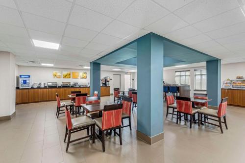 DemopolisComfort Inn US Hwy 80的一间设有桌椅和蓝色柱子的用餐室