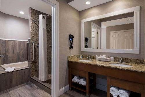 普拉茨堡Comfort Inn & Suites Plattsburgh - Morrisonville的一间带两个盥洗盆和大镜子的浴室