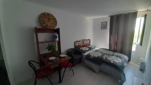 塞尔吉STUDIO TRES PROPRE de 18 m2的卧室配有一张床,墙上挂着一个钟