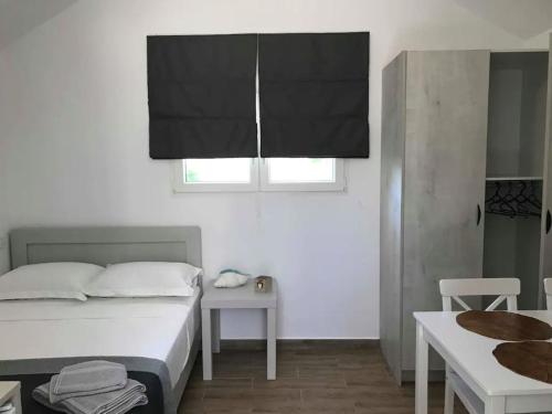 库鲁塔Calma Kourouta Apartments的一间卧室配有一张床、一张桌子和一个窗户。