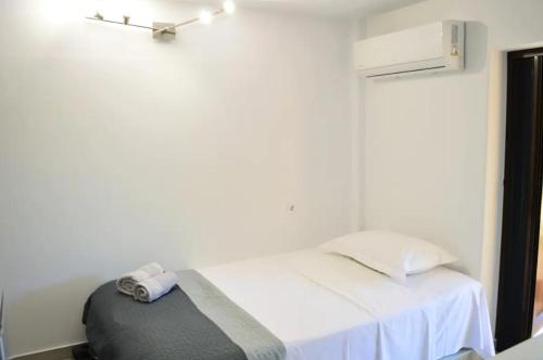 库鲁塔Calma Kourouta Apartments的卧室配有白色床和灰色的搁脚凳