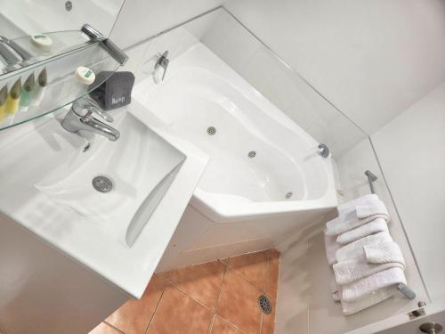 奥克兰Botany Palms Motel的白色的浴室设有水槽和浴缸。