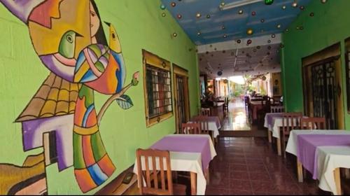 La PalmaHostal y Restaurante Posada Real的墙上画画的餐厅