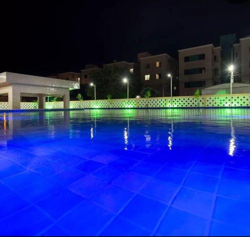 保罗阿方索城Apartamento Aconchegante em Paulo Afonso的夜间大型游泳池,灯光蓝色
