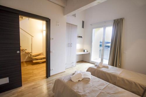 阿雷佐Hotel Arezzo ASC的一间卧室设有两张床和大窗户