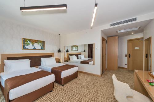 伊斯坦布尔Hotel Boursier 1 & Spa的酒店客房配有两张床和一张书桌