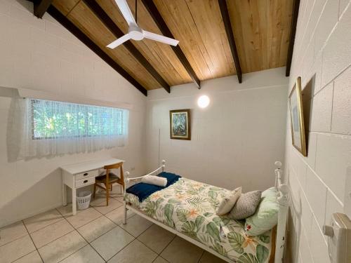 库兰达Botanica House Kuranda的一间卧室设有一张床、一张桌子和天花板