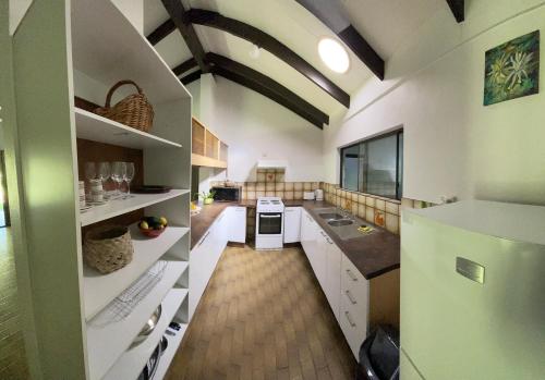 库兰达Botanica House Kuranda的一间大厨房,配有白色的橱柜和绿色的冰箱