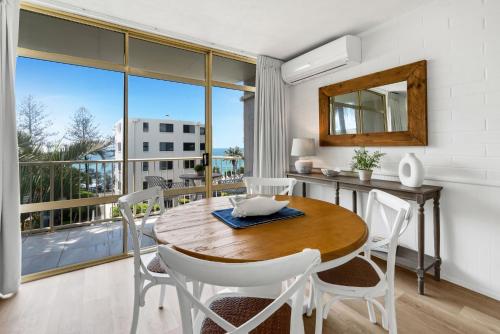库鲁姆海滩冲浪舞公寓式酒店的一间带桌椅的用餐室和一个阳台