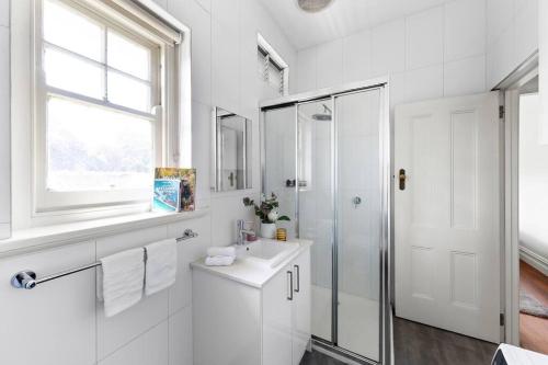 墨尔本Art Deco Hideaway - St Kilda的白色的浴室设有水槽和淋浴。