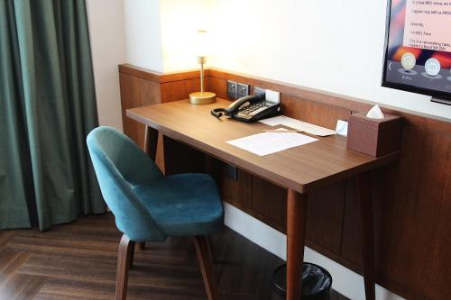怡保唯裕酒店的客房设有一张桌子、一把椅子和一部电话