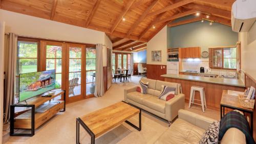 比奇沃斯Beechworth Cedar Cottages的带沙发和电视的客厅以及厨房。