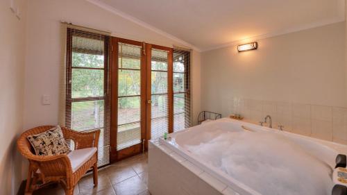 比奇沃斯Beechworth Cedar Cottages的窗户客房内的白色大浴缸