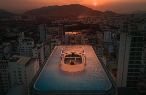 芽庄Grand Tourane Nha Trang Hotel的坐在大楼顶上的小船