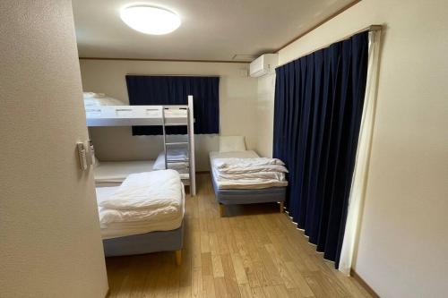 鸣泽市富士山下Cottage-B的客房设有两张床和一张双层床。