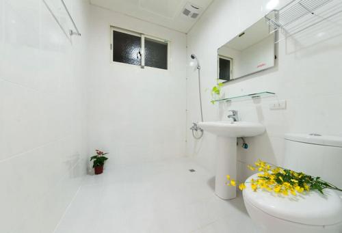 五结自由天地民宿的白色的浴室设有卫生间和水槽。