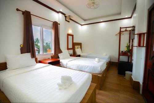 万象Nana Vientiane Hotel的酒店客房设有两张床和窗户。