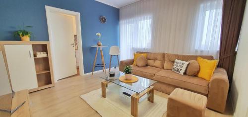 奥拉迪亚2 Bedrooms - Skyblue Central apartment的客厅配有沙发和桌子