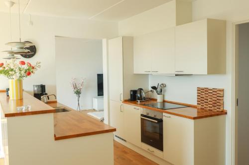 哥本哈根Penthouse - Amazing views & hygge的厨房配有白色橱柜和台面