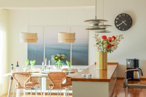哥本哈根Penthouse - Amazing views & hygge的厨房配有桌椅和时钟