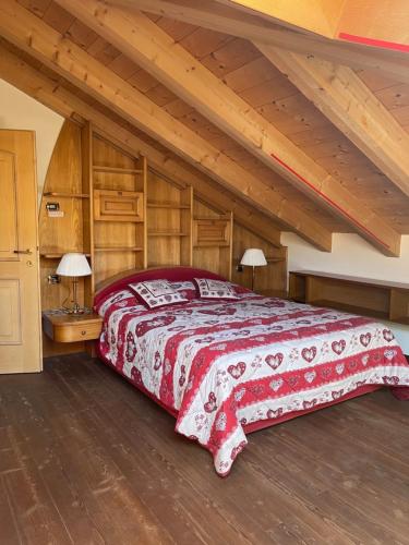 佩伊奥Alpino Charme Apartments的一间卧室设有一张大床和木制天花板。