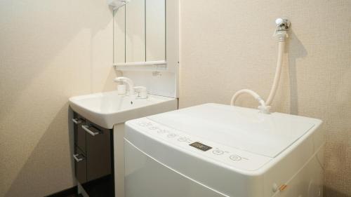 京都KAMON INN AIHUKA的一间带水槽和洗衣机的浴室