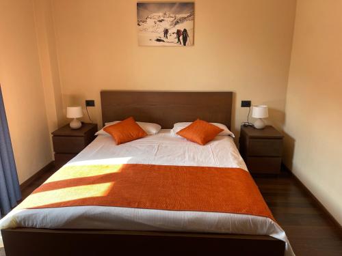 波尔莱扎B & B Sul Lago的一间卧室配有一张带橙色枕头的大床