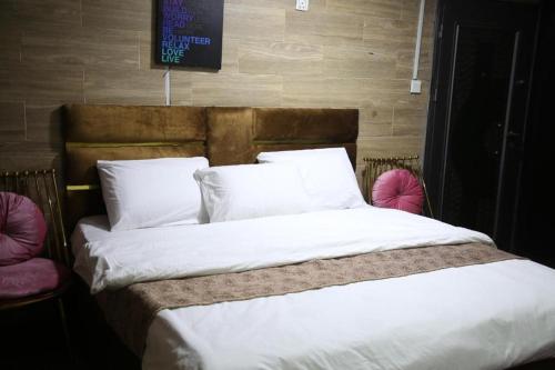 拉各斯Mission Pavilion的卧室配有一张带白色床单和枕头的大床。