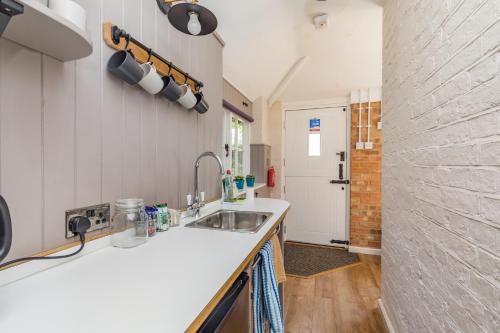 HurstpierpointOld Mill Lodge by Huluki Sussex Stays的厨房设有水槽和砖墙