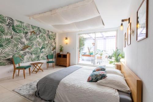 马赛La petite Toscane de Marseille的一间卧室配有一张大床和一张桌子及椅子