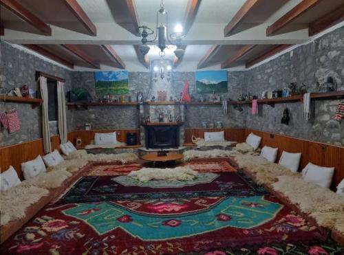 CerenGuest House Korabi的客厅的地板上铺有大地毯