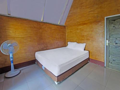 LukOYO 92419 Rejeng Homestay Near Kerta Gangga Waterfall的一间带一张床和风扇的小卧室