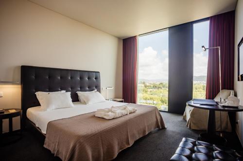 维亚纳堡阿克西斯维亚纳商务SPA酒店的一间卧室设有一张大床和大窗户